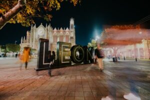 Vibrant night view of León's iconic cathedral with blurred motion of people, captured in México.